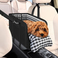 Black center console dog car seat with a small dog resting inside, fitted between the front seats