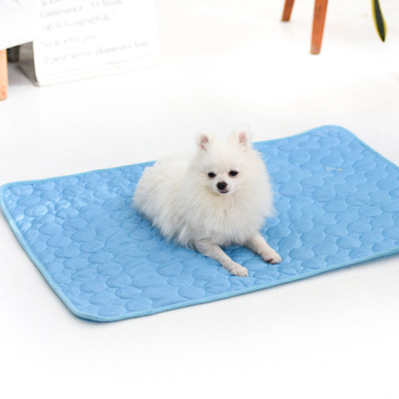 Small white dog resting on the Petananda ice-silk cooling mat in light blue